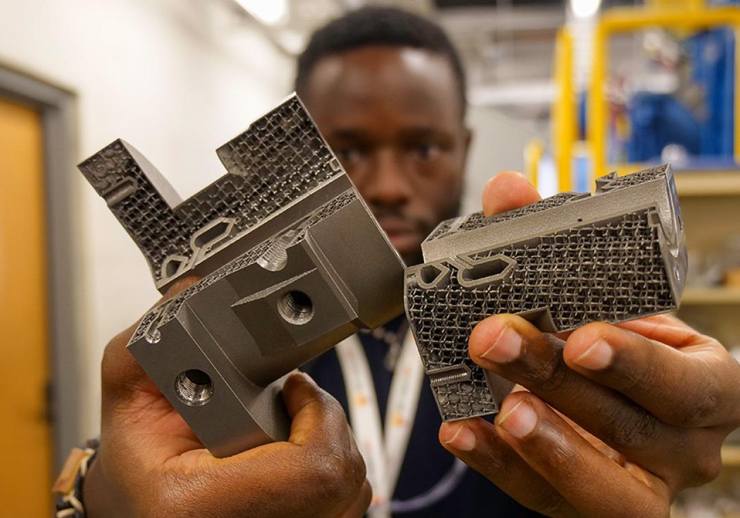 Man holding metal components up to the camera.