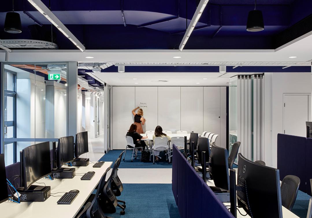 Computer banks and a meeting room at UQ Cyber Hub.