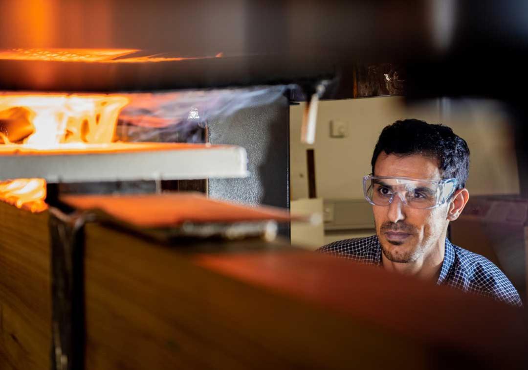 UQ expert surveys a flaming machine in one of the advanced manufacturing labs.