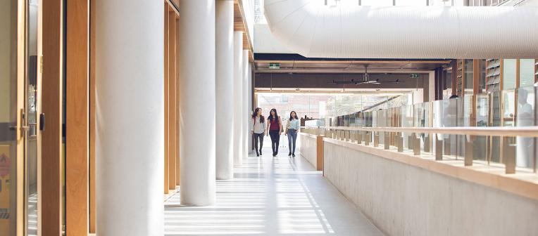 Three people walking through the advanced engineering building. 