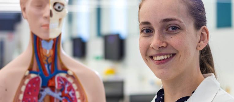 A woman with a model of the human body