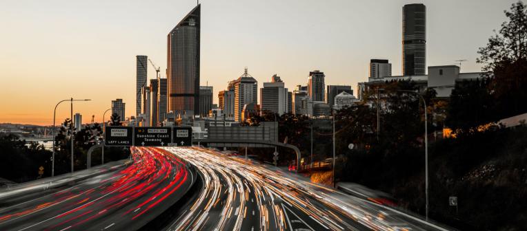 Traffic moving past Brisbane city at sunset