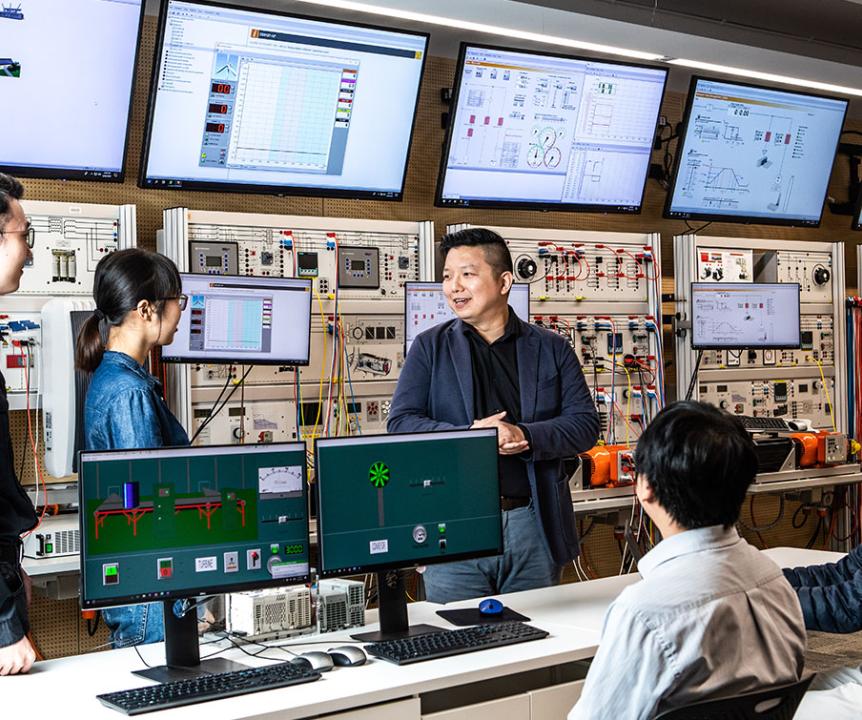 Students and teachers in a computer science lab. 