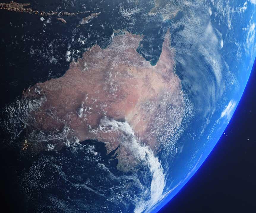 Australia as seen from space with sunlight and clouds hitting parts of the country