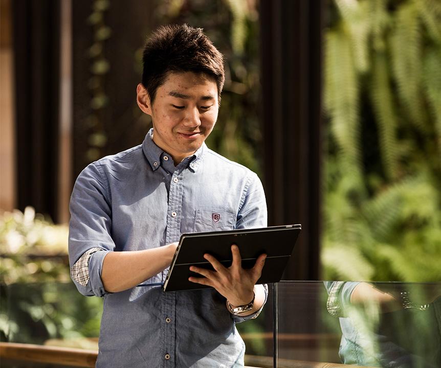 A man walking and using an iPad.