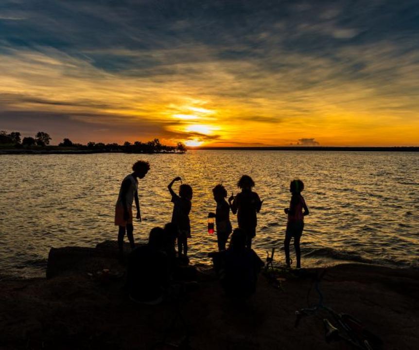 Silhouette of children playing on rocks at sunset in aboriginal community of Maningrida NT Australia.jpg