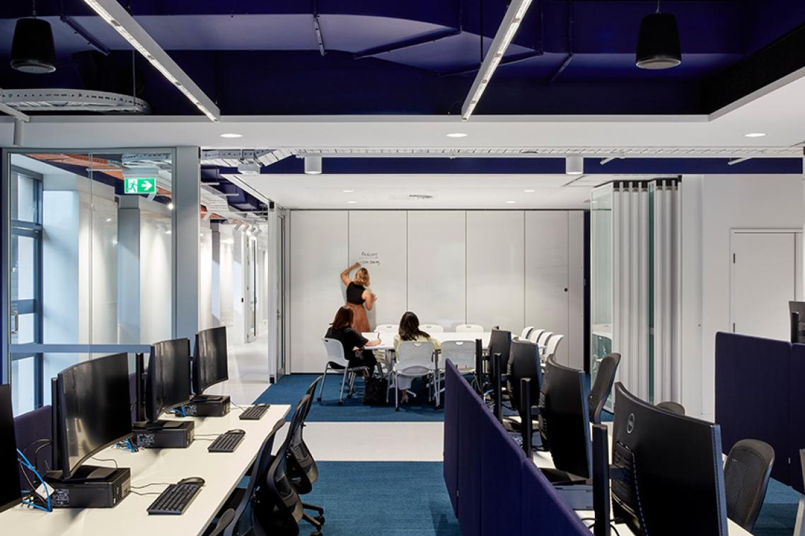 Computer banks and a meeting room at UQ Cyber Hub.