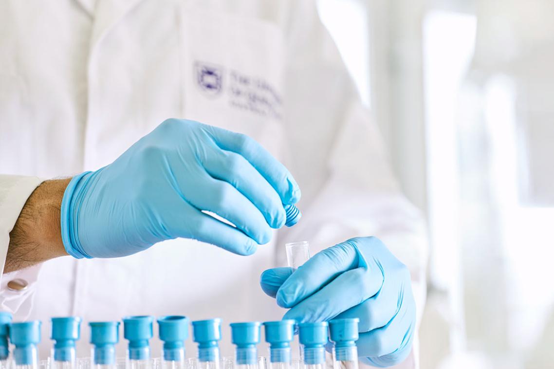 Researcher with a row of test tubes