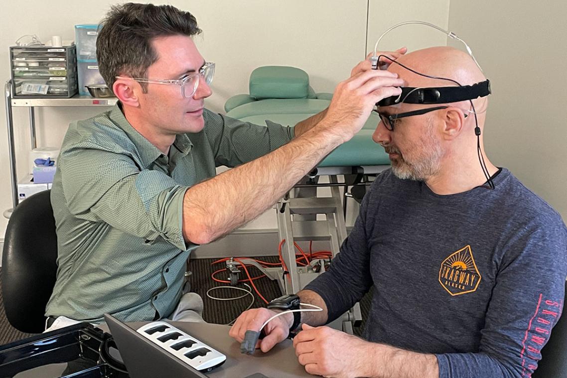 Dr David Klyne fits Dr Wolbert van den Hoorn with a sleep monitoring device on his head.