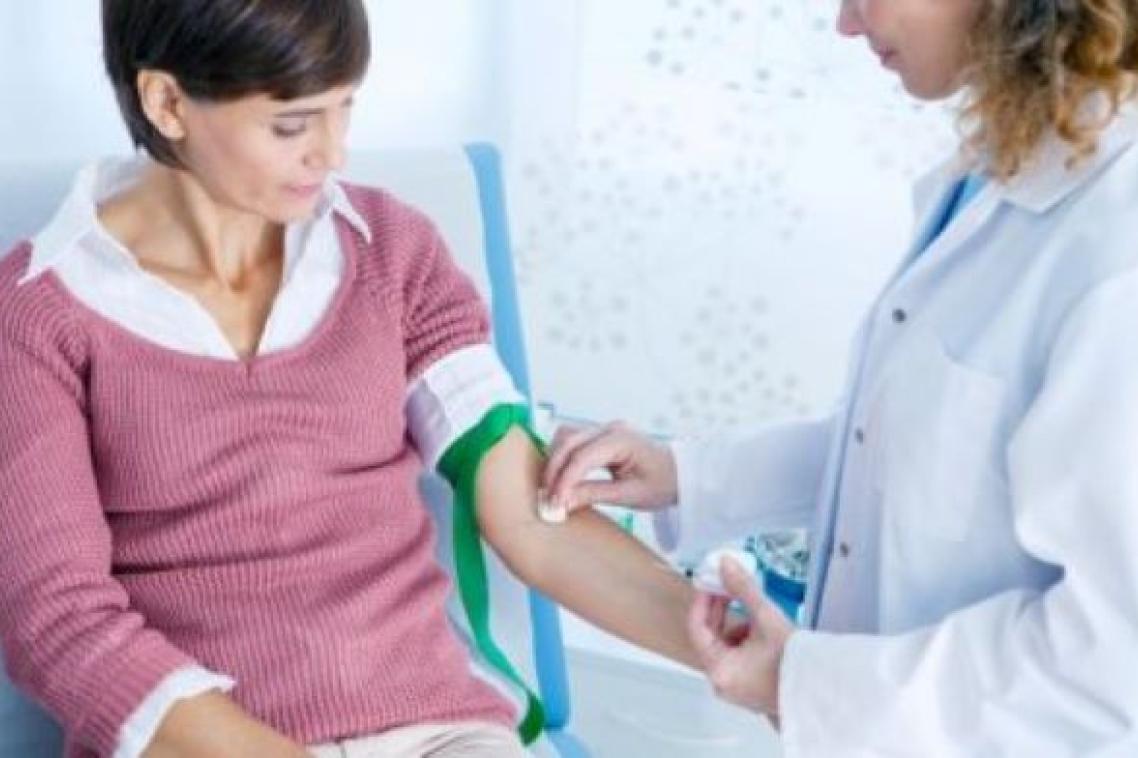 A nurse swabs a patient's arm in preparation for a blood test