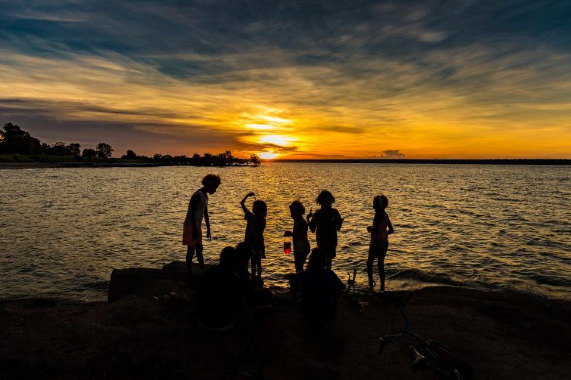 Silhouette of children playing on rocks at sunset in aboriginal community of Maningrida NT Australia.jpg